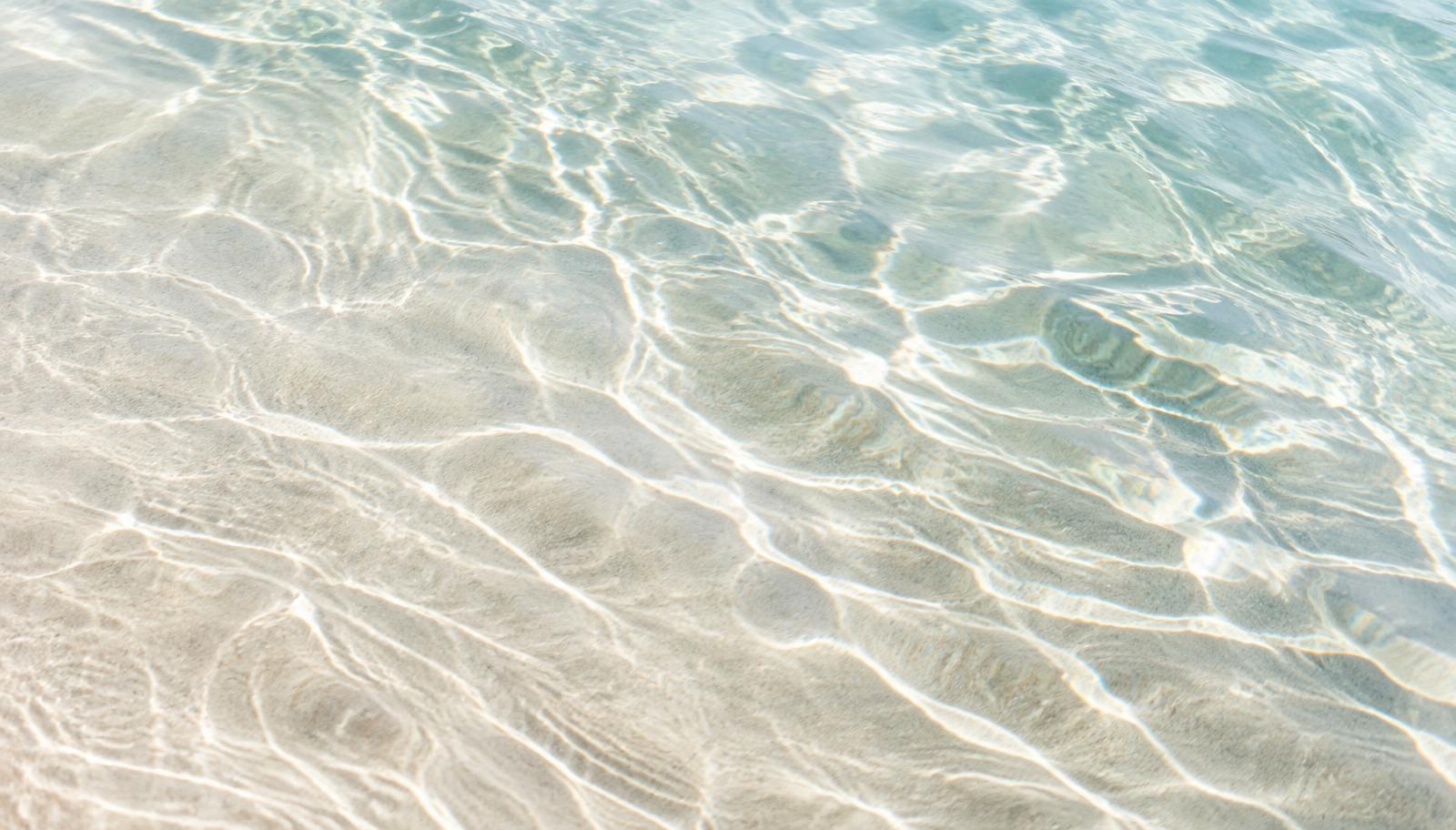 Eau claire ondulant sur le sable